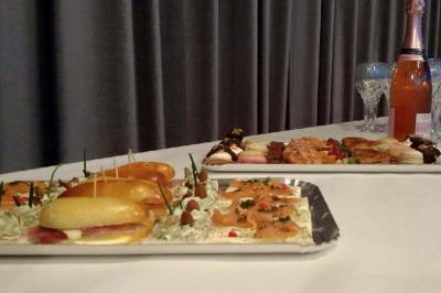 Plateaux de petits fours salés et sucrés avec une bouteille de champagne rosé et des verres sur une table blanche.