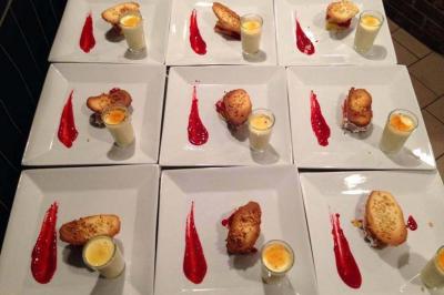 Assiettes dressées avec un dessert composé de verrines, pâtisseries et coulis rouge disposé en trait.