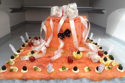 Plateau décoratif de saumon fumé avec rubans, olives, citrons sculptés et garnitures élégantes.