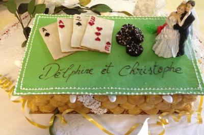 Gâteau de mariage décoré de cartes à jouer, de choux, et d'une figurine de couple, avec les prénoms Delphine et Christophe.