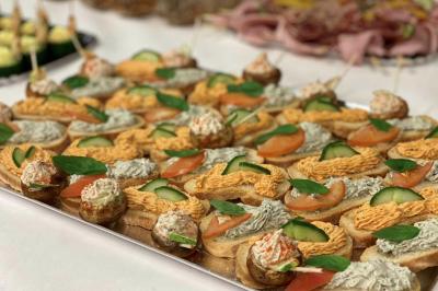 Plateau de canapés variés garnis de légumes, herbes fraîches et tartinades colorées, disposés sur une table blanche.