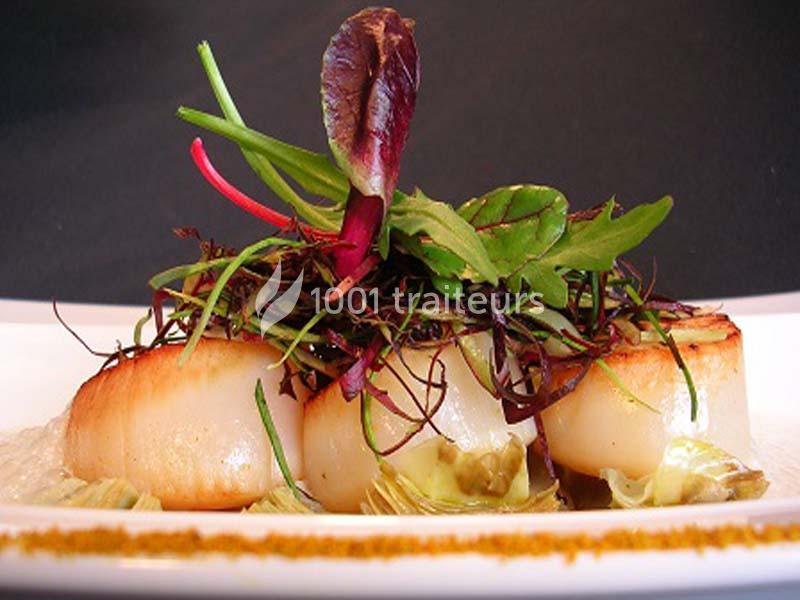 Assiette de noix de Saint-Jacques poêlées, garnies de jeunes pousses et accompagnées de légumes.