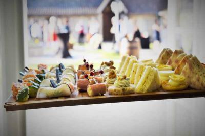 Plateau de bouchées salées et sucrées disposées sur une table, avec un événement flou en arrière-plan.