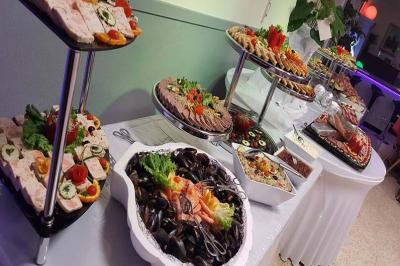 Buffet varié avec fruits de mer, charcuteries, salades et amuse-bouches disposés sur des plateaux.