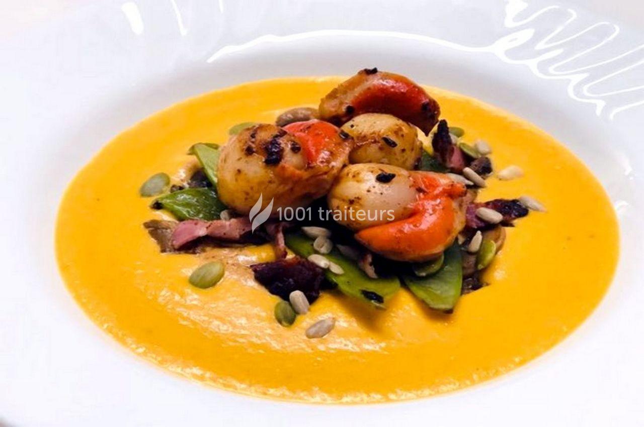 Noix de Saint-Jacques poêlées sur purée de légumes orange, accompagnées de légumes verts et graines.