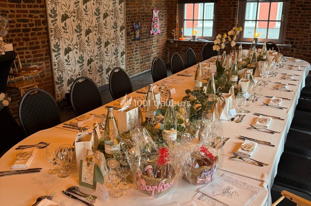 Table dressée pour un repas festif dans une salle en briques, décorée de lumières suspendues et de détails élégants.