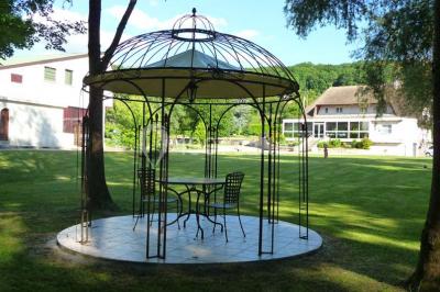 Salle décorée pour un événement avec tables dressées, chandeliers, nappes blanches et buffet garni en arrière-plan.