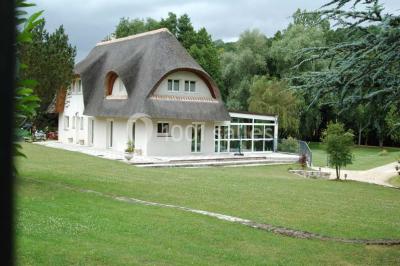 Salle décorée pour un événement avec tables dressées, chandeliers, nappes blanches et buffet garni en arrière-plan.
