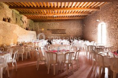 Église illuminée de nuit avec un clocher éclairé, vue depuis une allée avec des braseros allumés au premier plan.