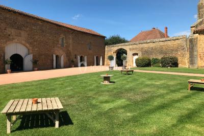 Église illuminée de nuit avec un clocher éclairé, vue depuis une allée avec des braseros allumés au premier plan.