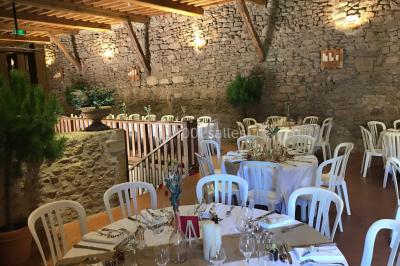 Église illuminée de nuit avec un clocher éclairé, vue depuis une allée avec des braseros allumés au premier plan.