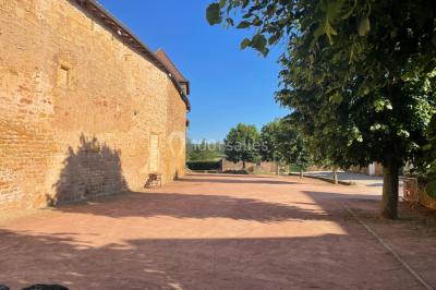 Église illuminée de nuit avec un clocher éclairé, vue depuis une allée avec des braseros allumés au premier plan.