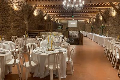 Église illuminée de nuit avec un clocher éclairé, vue depuis une allée avec des braseros allumés au premier plan.