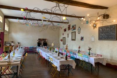 Lit double avec drap blanc, encadré par deux tables de chevet et lampes, dans une chambre au mur bleu et sol en bois.