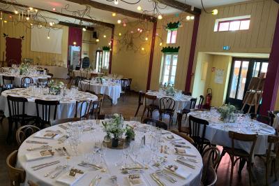 Lit double avec drap blanc, encadré par deux tables de chevet et lampes, dans une chambre au mur bleu et sol en bois.