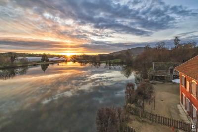 Lit double avec drap blanc, encadré par deux tables de chevet et lampes, dans une chambre au mur bleu et sol en bois.