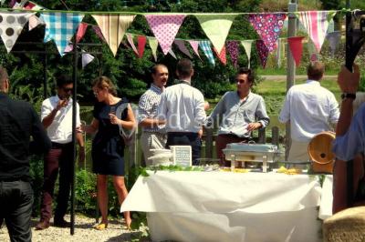 Lit double avec drap blanc, encadré par deux tables de chevet et lampes, dans une chambre au mur bleu et sol en bois.