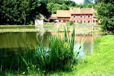 Lit double avec drap blanc, encadré par deux tables de chevet et lampes, dans une chambre au mur bleu et sol en bois.