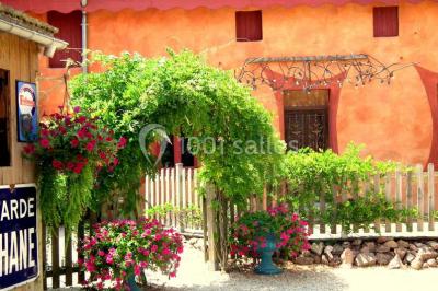 Lit double avec drap blanc, encadré par deux tables de chevet et lampes, dans une chambre au mur bleu et sol en bois.