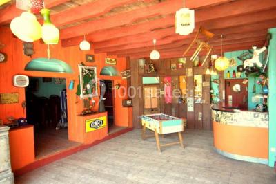 Lit double avec drap blanc, encadré par deux tables de chevet et lampes, dans une chambre au mur bleu et sol en bois.