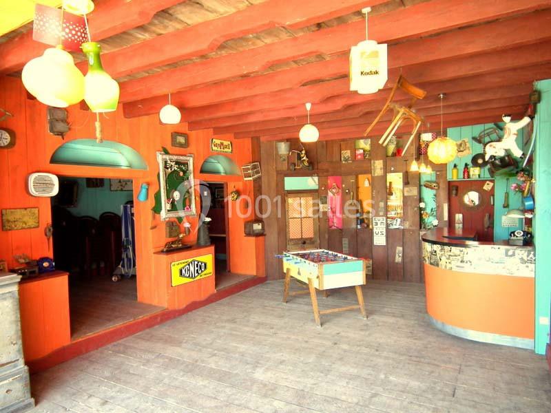 Intérieur coloré d'un espace rétro avec des objets vintage, un baby-foot et un comptoir décoré.