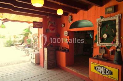 Lit double avec drap blanc, encadré par deux tables de chevet et lampes, dans une chambre au mur bleu et sol en bois.