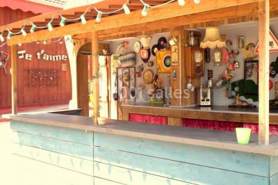 Lit double avec drap blanc, encadré par deux tables de chevet et lampes, dans une chambre au mur bleu et sol en bois.