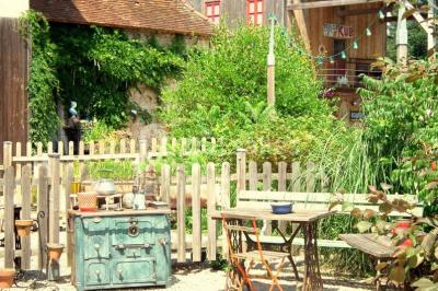 Lit double avec drap blanc, encadré par deux tables de chevet et lampes, dans une chambre au mur bleu et sol en bois.