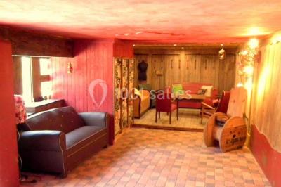 Lit double avec drap blanc, encadré par deux tables de chevet et lampes, dans une chambre au mur bleu et sol en bois.