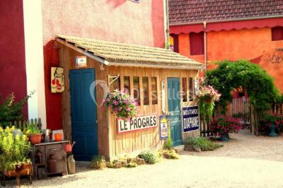 Lit double avec drap blanc, encadré par deux tables de chevet et lampes, dans une chambre au mur bleu et sol en bois.
