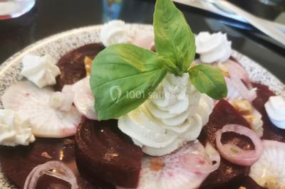 Assiette de salade composée avec melon, tomate, mozzarella, basilic et fleurs comestibles, accompagnée de toasts et foie…