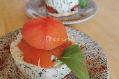 Assiette de salade composée avec melon, tomate, mozzarella, basilic et fleurs comestibles, accompagnée de toasts et foie…
