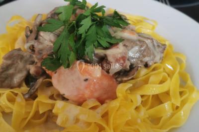 Assiette de salade composée avec melon, tomate, mozzarella, basilic et fleurs comestibles, accompagnée de toasts et foie…