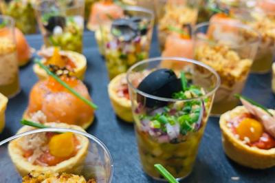 Plateau de bouchées apéritives variées comprenant légumes, foie gras, saumon fumé et feuilletés.