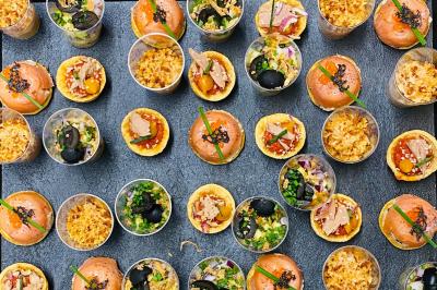 Plateau de bouchées apéritives variées comprenant légumes, foie gras, saumon fumé et feuilletés.