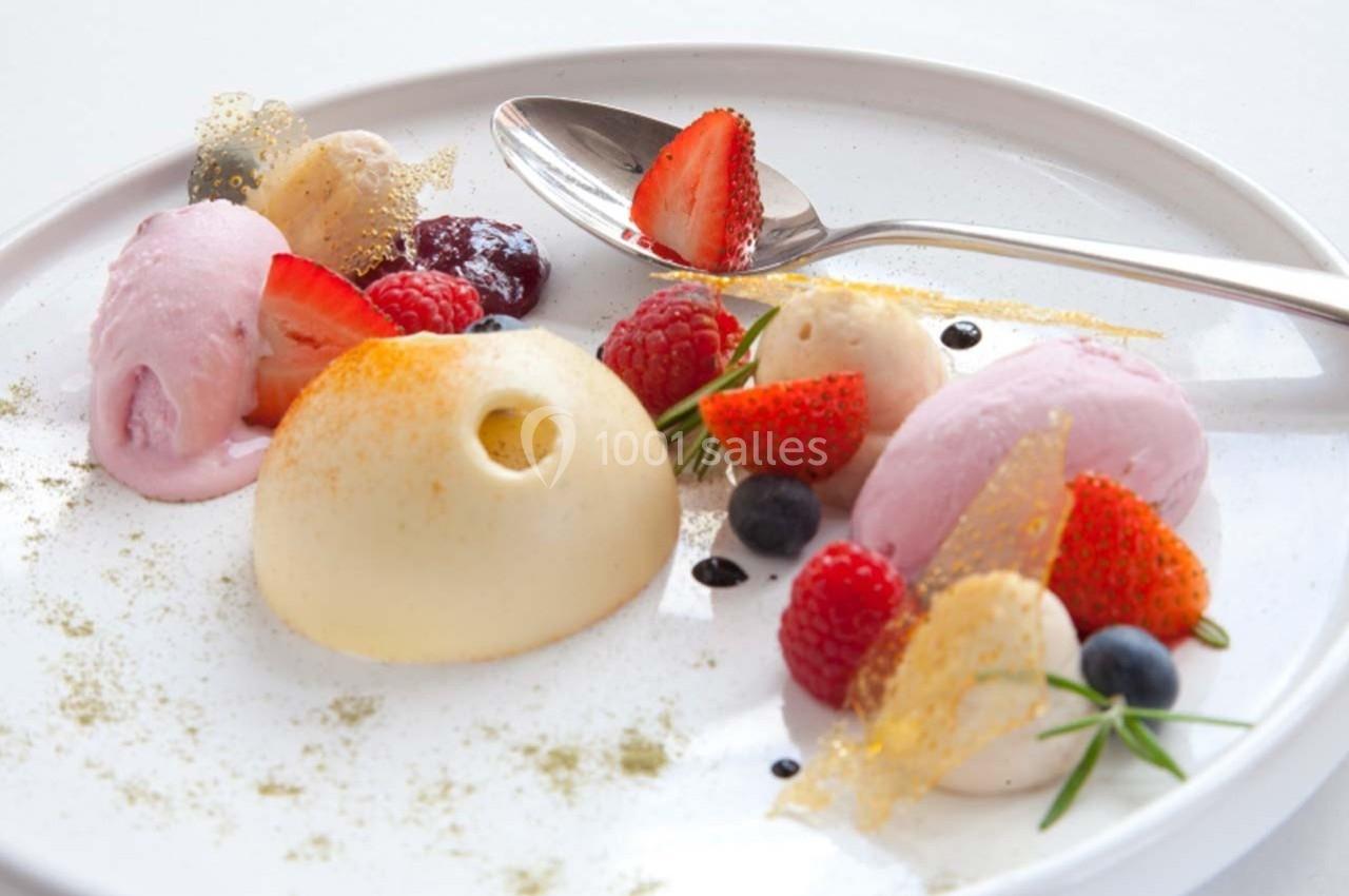 Assiette de dessert composée de mousse, sorbets, fruits rouges frais, éclats de caramel et décorations comestibles.