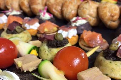 Assiette gastronomique avec viande, foie gras, cubes de fromage, sauce décorative et garniture verte.