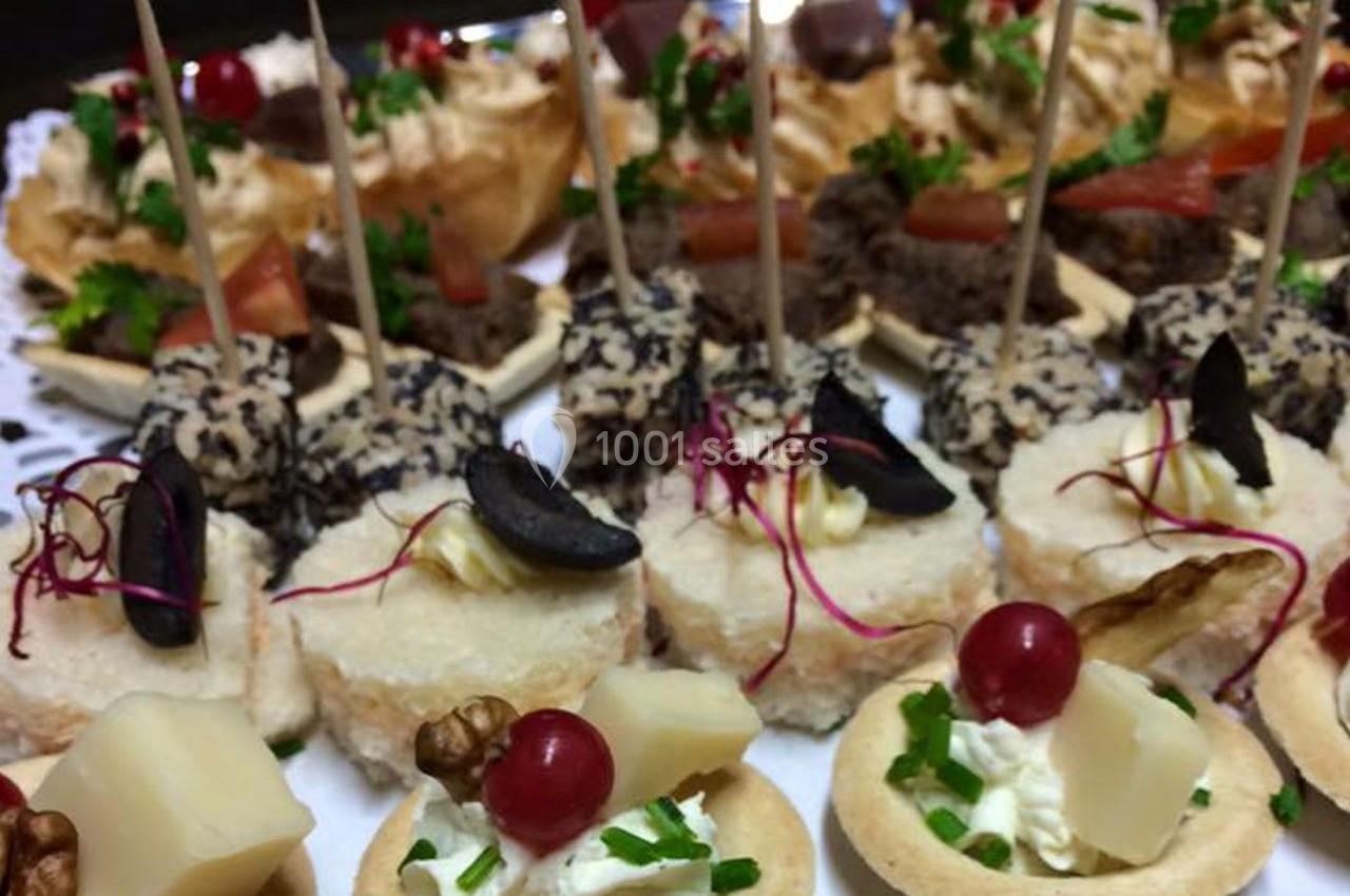 Plateau de canapés variés avec fromages, fruits, herbes fraîches et brochettes, présenté pour un buffet ou un apéritif.