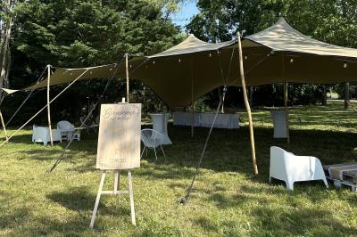 Table décorée avec des verres à pied, des fleurs roses et blanches, et des éléments de décoration en bois et dentelle.