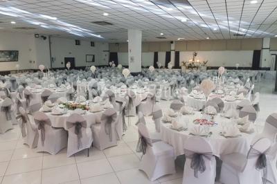 Lettres rouges formant le mot ’LOVE’ sur un tapis rouge, entourées de petites décorations blanches, en extérieur.