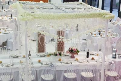 Lettres rouges formant le mot ’LOVE’ sur un tapis rouge, entourées de petites décorations blanches, en extérieur.