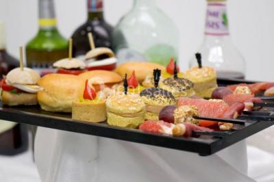 Lettres rouges formant le mot ’LOVE’ sur un tapis rouge, entourées de petites décorations blanches, en extérieur.