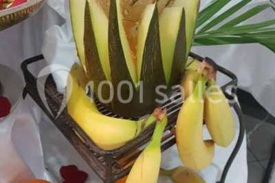 Lettres rouges formant le mot ’LOVE’ sur un tapis rouge, entourées de petites décorations blanches, en extérieur.