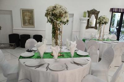 Lettres rouges formant le mot ’LOVE’ sur un tapis rouge, entourées de petites décorations blanches, en extérieur.