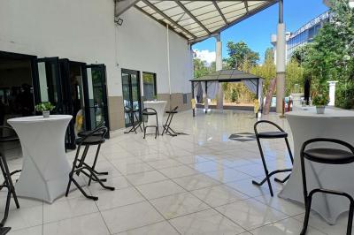 Lettres rouges formant le mot ’LOVE’ sur un tapis rouge, entourées de petites décorations blanches, en extérieur.