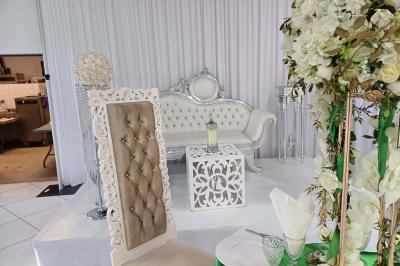 Lettres rouges formant le mot ’LOVE’ sur un tapis rouge, entourées de petites décorations blanches, en extérieur.