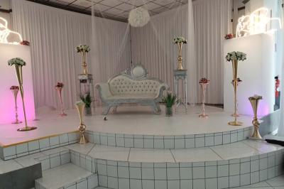 Lettres rouges formant le mot ’LOVE’ sur un tapis rouge, entourées de petites décorations blanches, en extérieur.