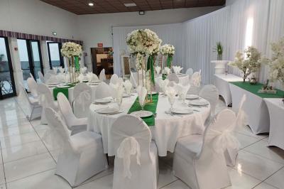 Lettres rouges formant le mot ’LOVE’ sur un tapis rouge, entourées de petites décorations blanches, en extérieur.