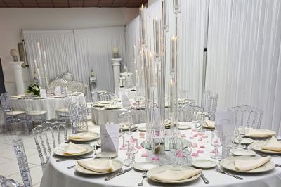 Lettres rouges formant le mot ’LOVE’ sur un tapis rouge, entourées de petites décorations blanches, en extérieur.