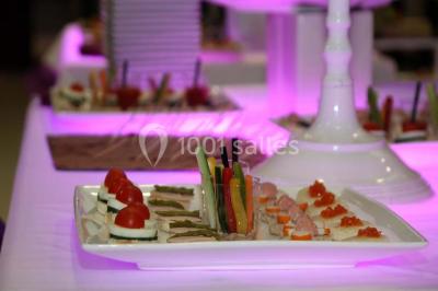 Plateau de sushis variés avec saumon, riz, légumes et feuilles d'endive, présenté sur un support transparent.